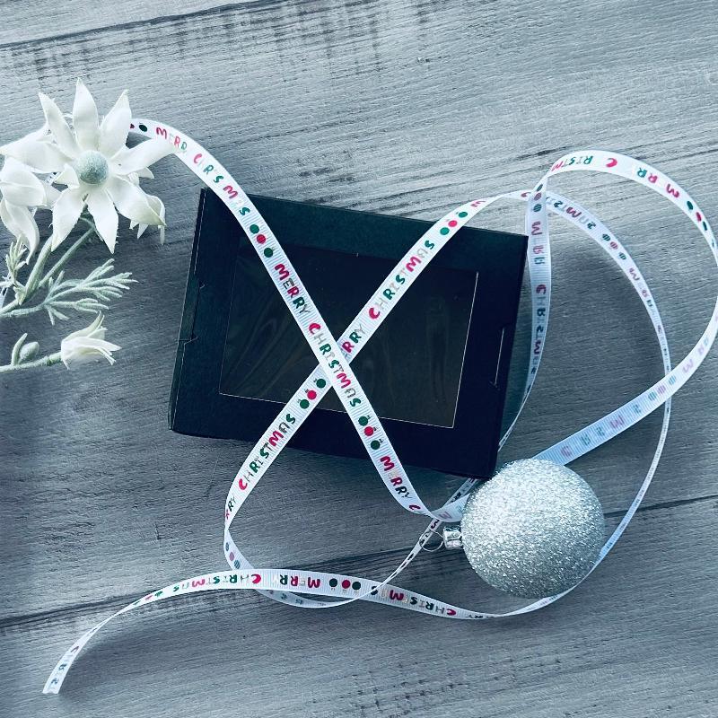 10mm x 20mt grosgrain white ribbon with red, green & old merry Christmas print with black gift box and bauble