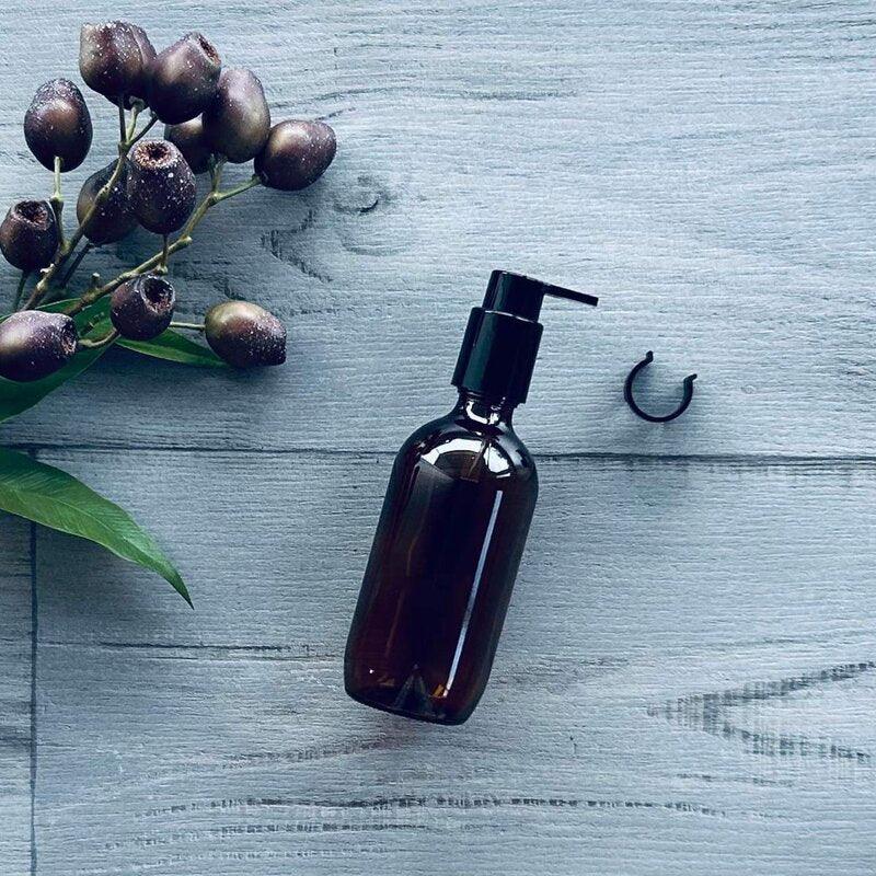 200ml amber glass bottle with black pump and stopper on side