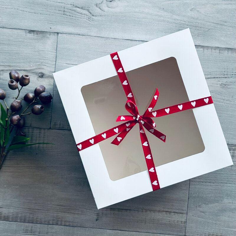 cake box with red and white heart ribbon