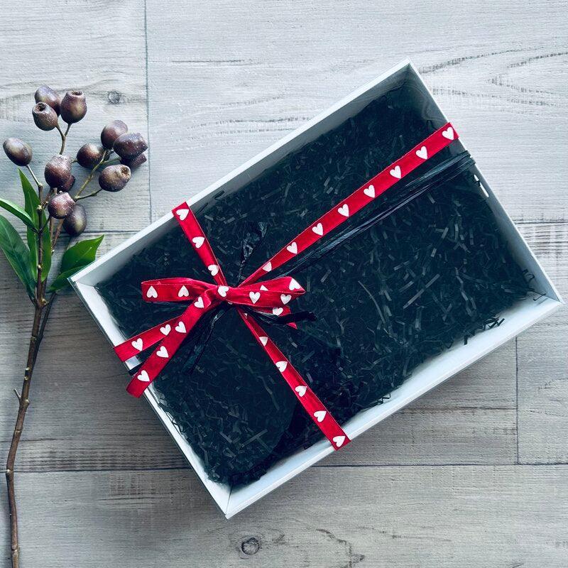 medium white hamper with clear lid, re and white heart ribbon and black shred