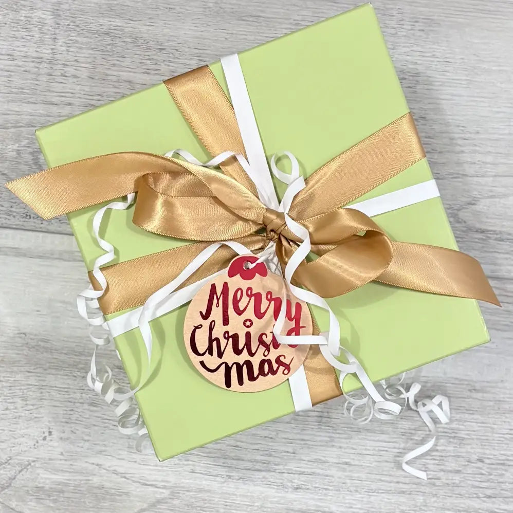 aloe gift box with gold satin ribbon white curling ribbon and merry christmas tag