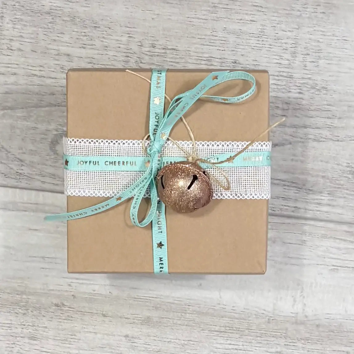 small kraft gift box with aqua christmas cheer ribbon and rose gold bell
