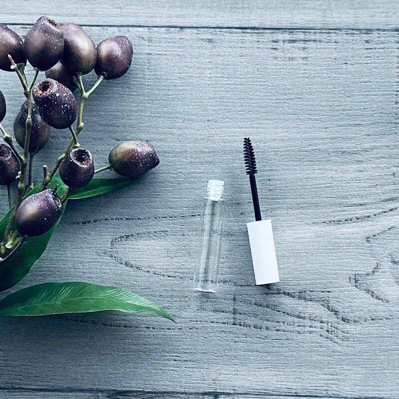 empty mascara wand and bottle clear white lid