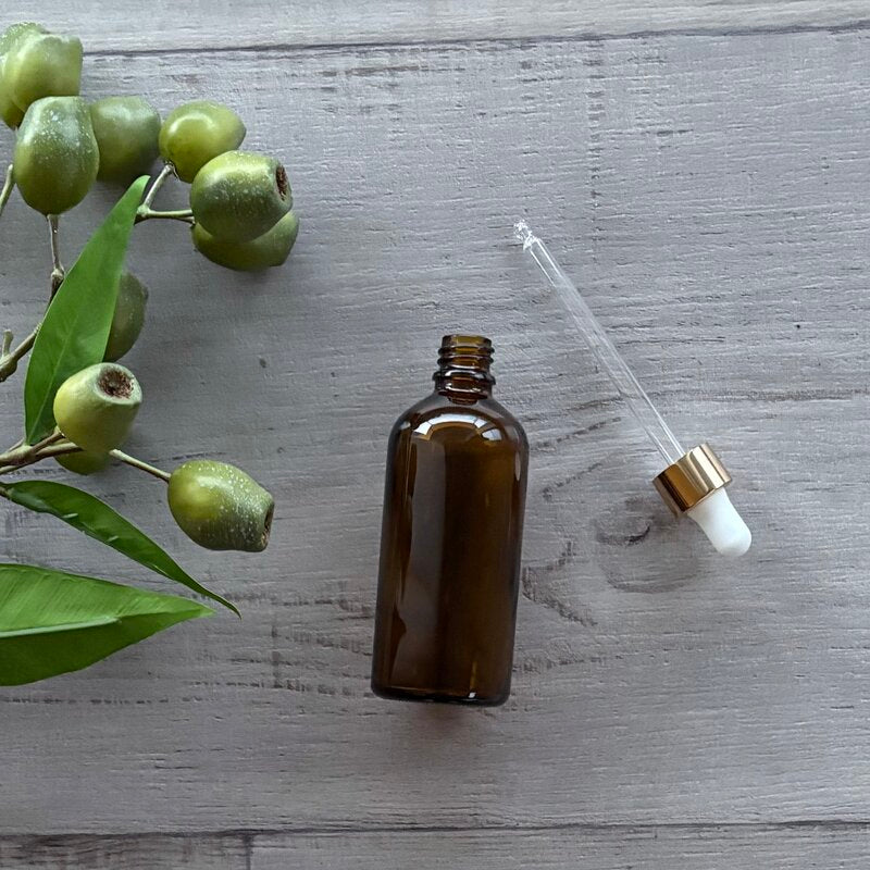 100ml amber glass bottle with gold & white dropper next to bottle @ centaur packaging