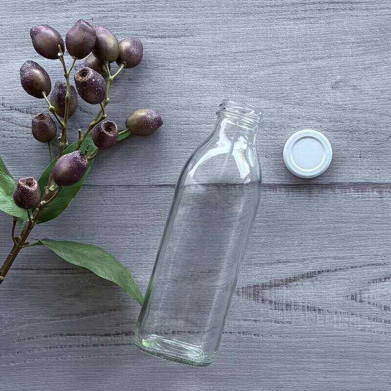 750ml clear glass juice bottle with white metal lid next to bottle