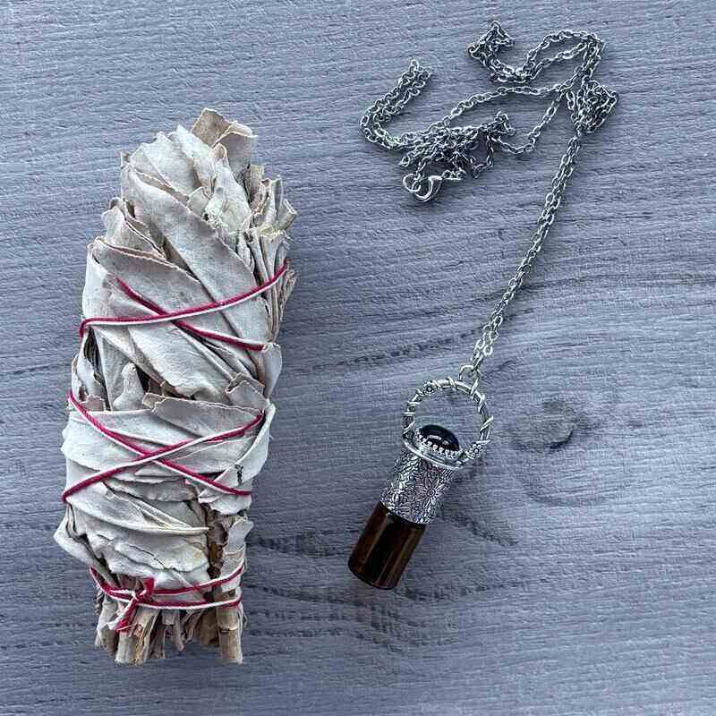 Amber glass roller with ornate silver lid with black onyx crystal stone & silver chain necklace pictured with sage smudge stick