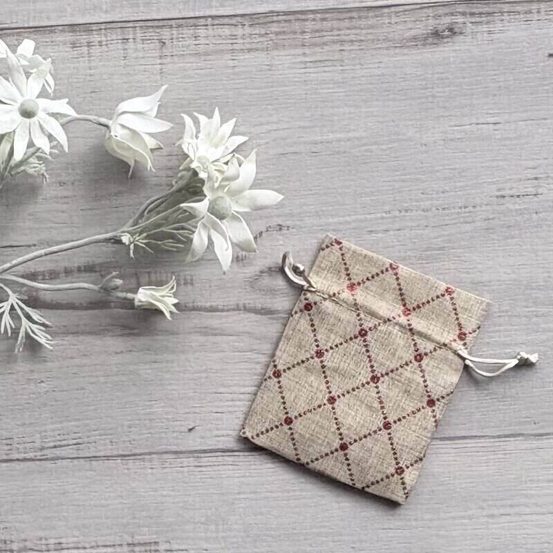Small Christmas gift bag with a red diamond pattern, made from polyester fabric with a jute-style appearance, measuring 10 x 12.5cm.