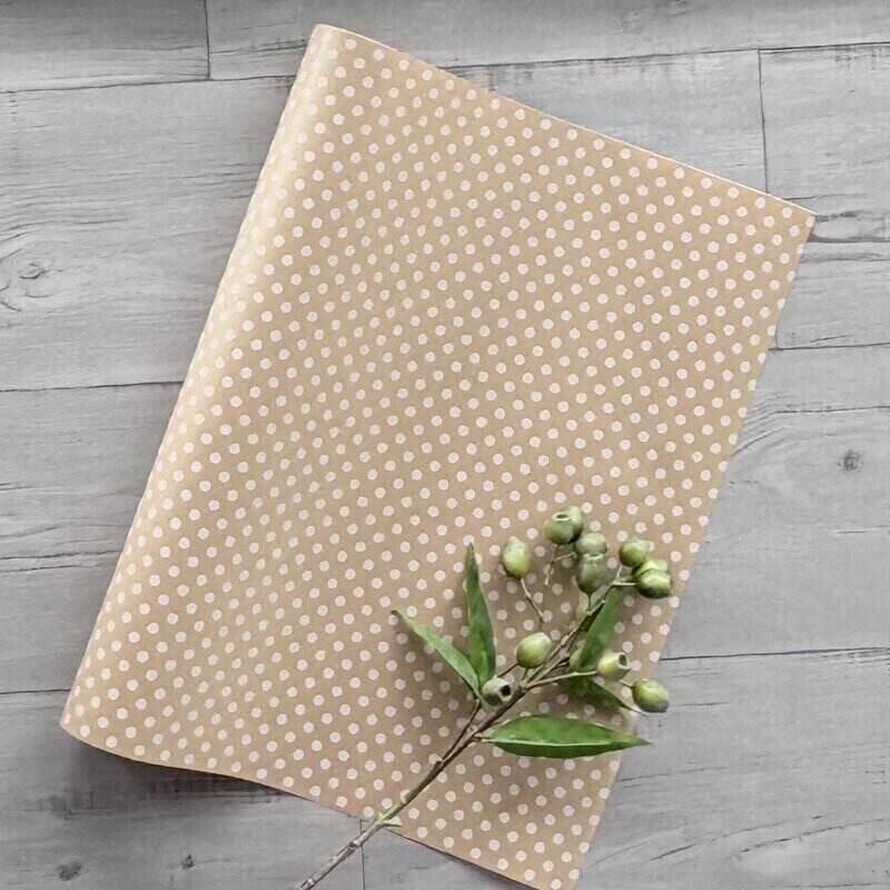 Natural kraft wrapping paper decorated with a white dot pattern, 80gsm, supplied in a 600mm wide by 40-metre roll.