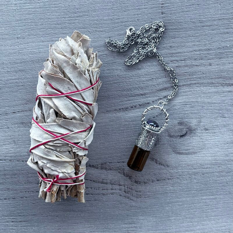 Amber glass roller with ornate silver lid with amethyst crystal stone & silver chain necklace pictured with sage smudge stick