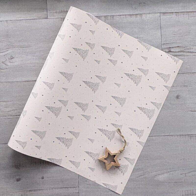 Starry Night Christmas wrapping paper featuring navy and charcoal Christmas trees and stars on a pinky-beige background, 80gsm, 600mm x 40m roll.