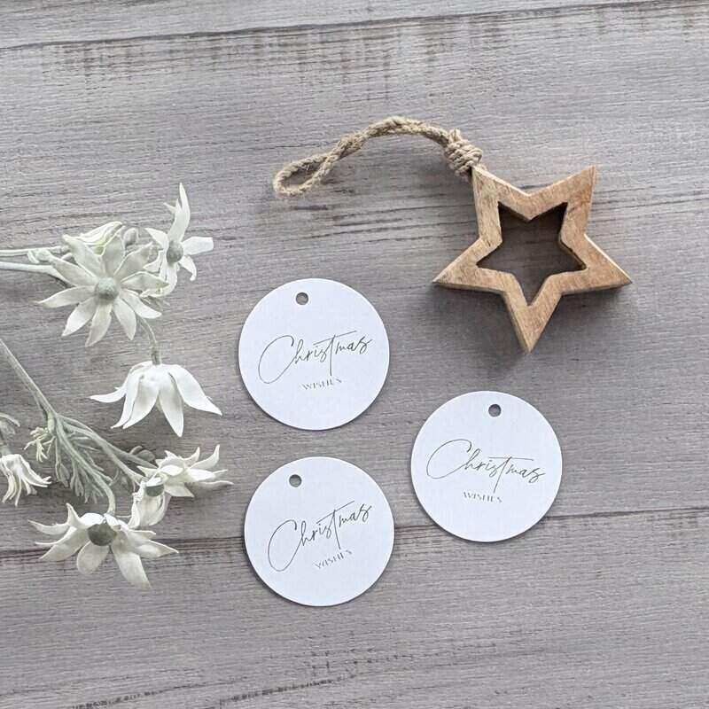 Round white cardboard Christmas gift tags printed with silver Christmas wishes, featuring a hanging hole for ribbon or twine, supplied in a pack of 20.