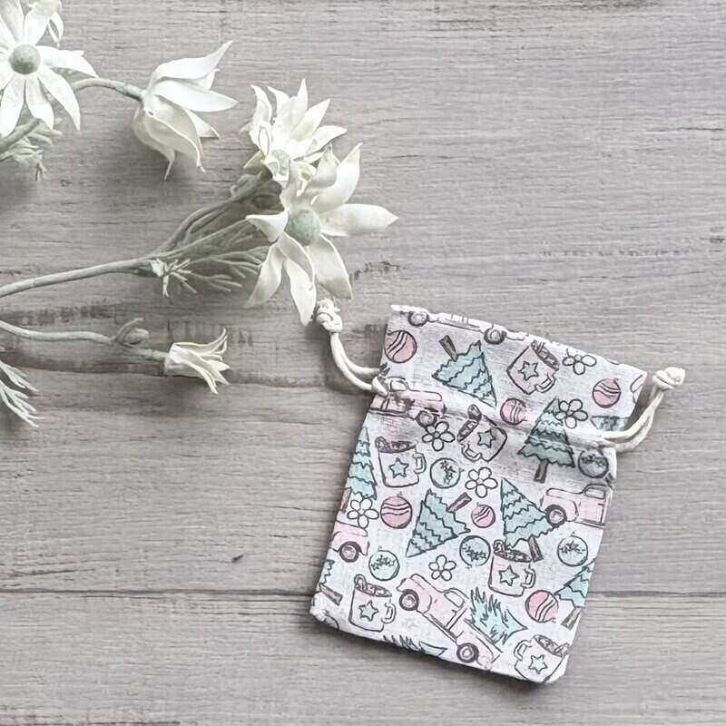 Cream calico Christmas gift pouch with a whimsical pink and green festive design, measuring 10 x 12.5cm.