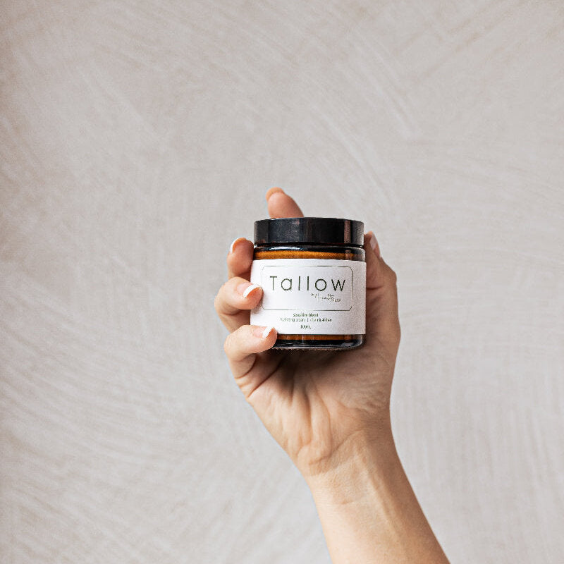 Tallow by health made 100ml amber jar held by hand