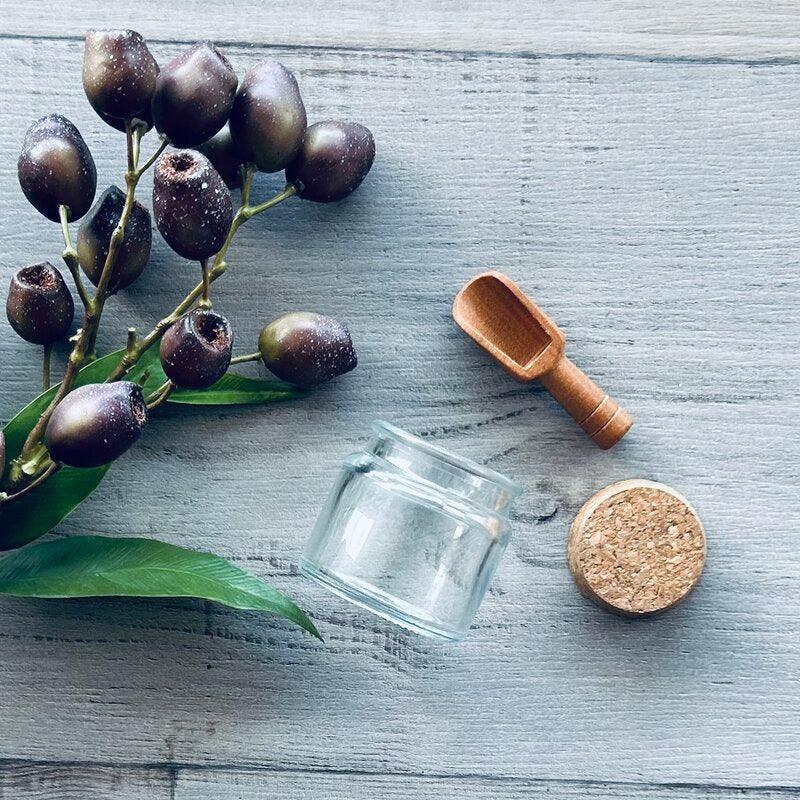 110ml clear jar with cork lid empty with wooden scoop next to it