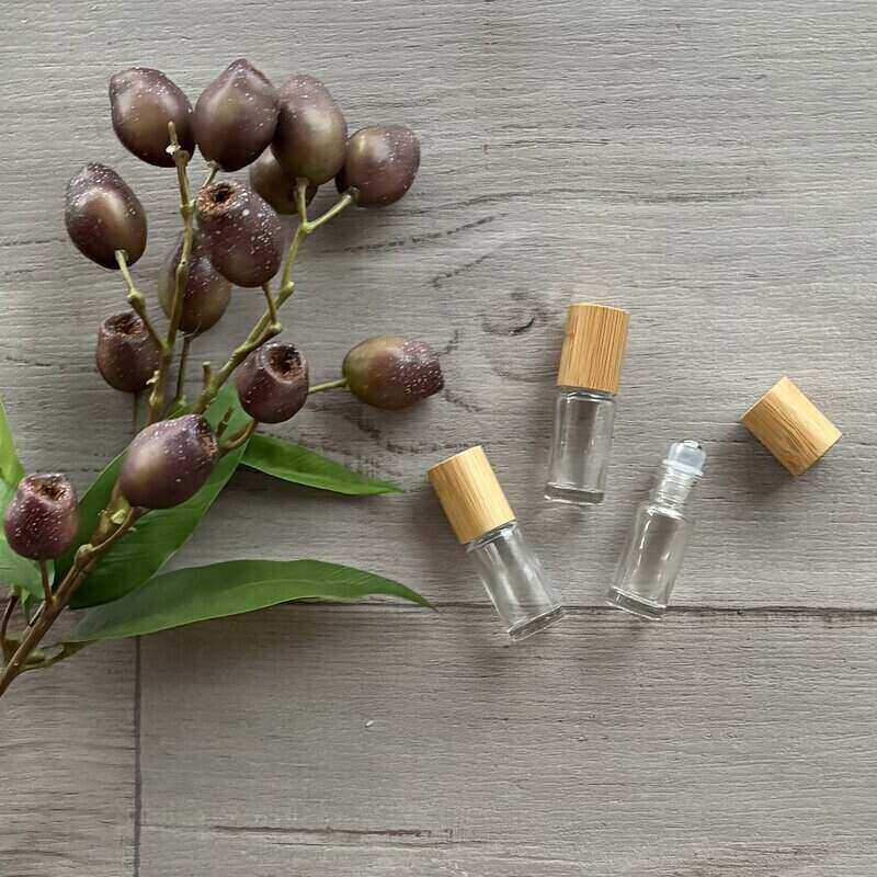5ml clear lass roller bottle with bamboo lid x 3 one lid off next to bottle