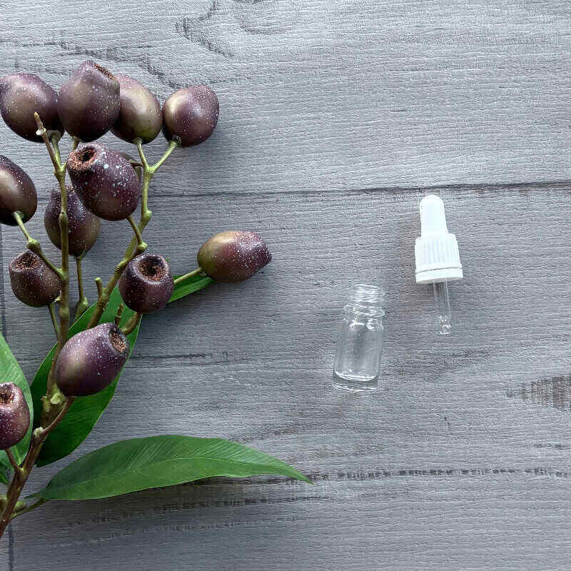 5ml Clear Thick Glass Bottle with White Dropper laying next to bottlecentaur packaging