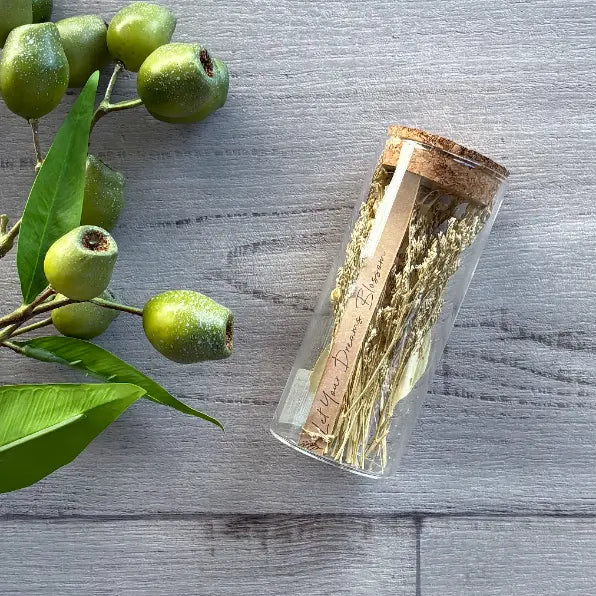 glass test tube with cork lid filled with natural colour botanicals with card saying 'let your dreams blossom"