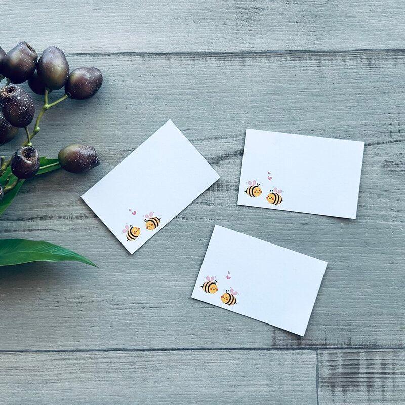 white tags with picture of two bees in love