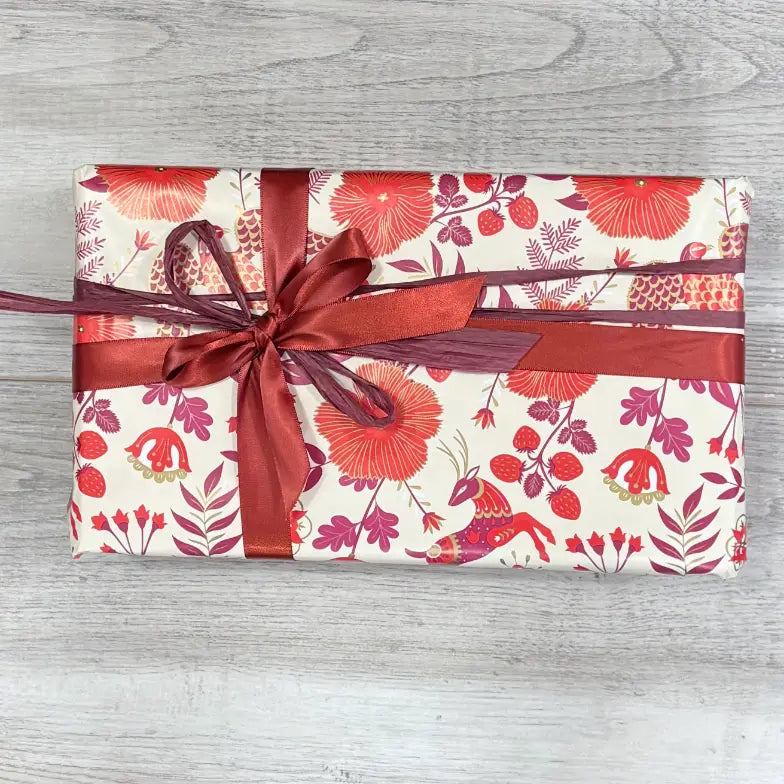 reindeer wrapping paper on box with red satin ribbon and burgundy raffia @ centaur packaging