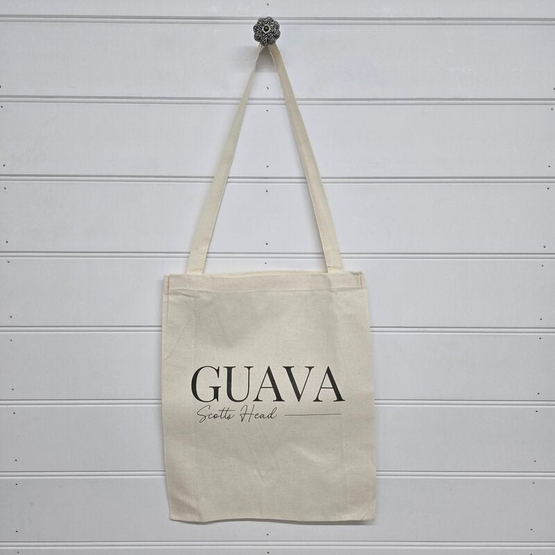 Beige tote bag with 'GUAVA Scottie Head' text on a wooden background