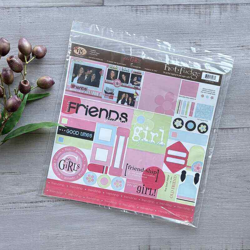 Packaged scrapbooking kit with colorful design elements on a wooden surface