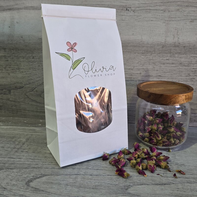 white tin tie bag with window custom printed next to rose petals in jar and table