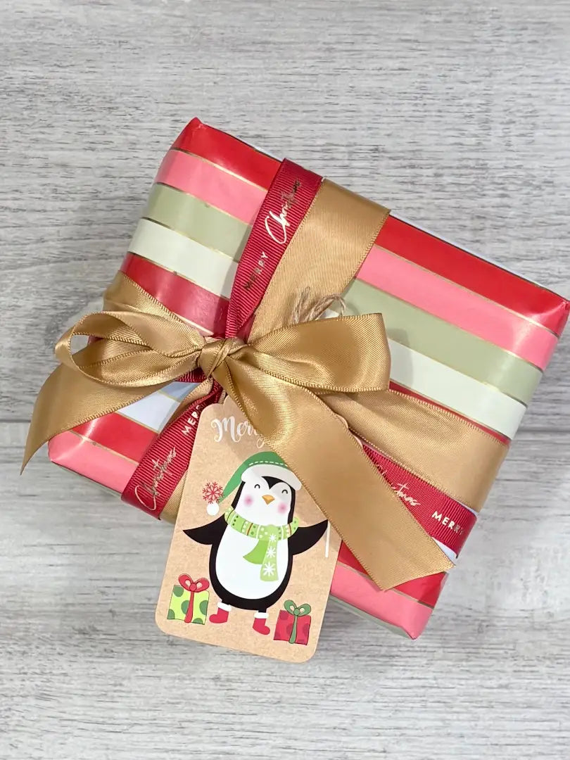 merry stripes wrapping paper with new gold satin ribbon, red and gold grosgrain christmas ribbon and penguin gift tag @centaur packaging
