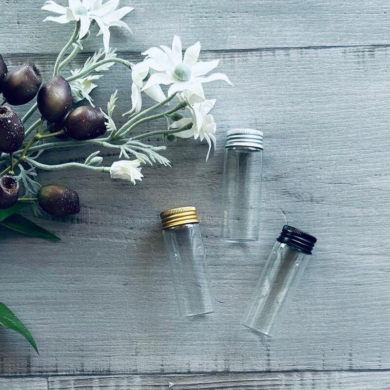 three test tubes with gold, black and silver lids